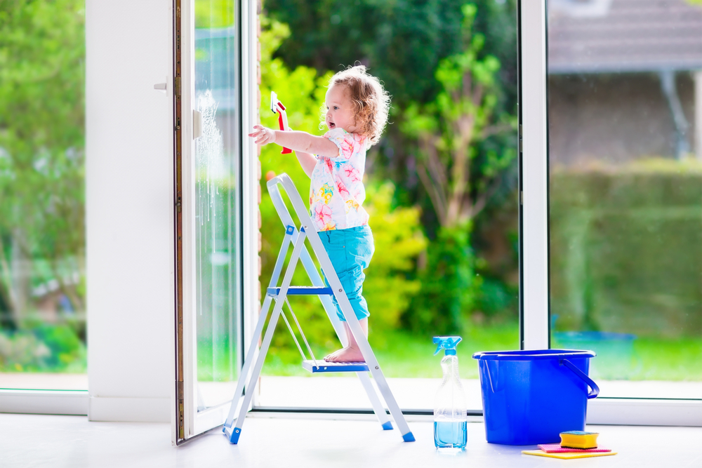 Malé dítě umývá francouzské okno