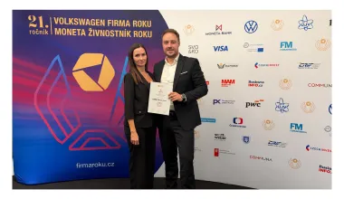 Dvojice s certifikátem LOMAX před soutěžní stěnou Firma roku 2026
