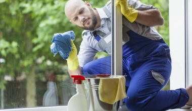 Pracovník úklidu při umývání okna