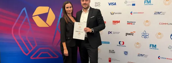 Dvojice s certifikátem LOMAX před soutěžní stěnou Firma roku 2026